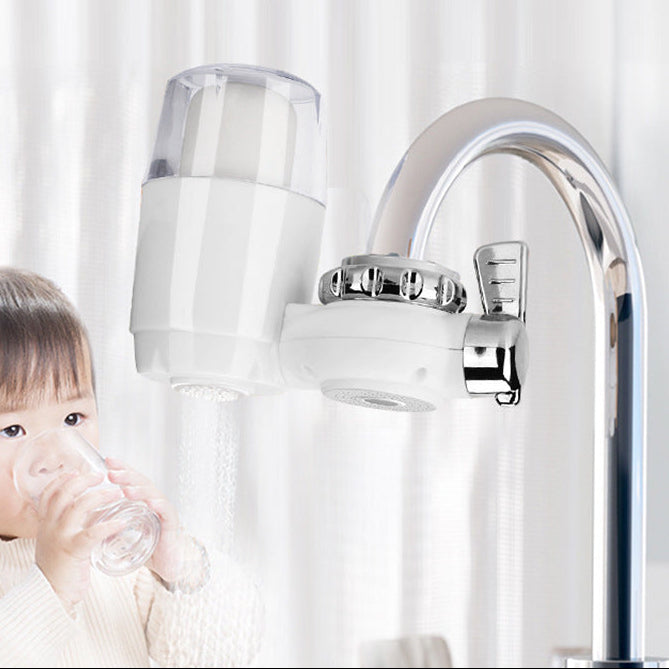 Child drinking water from a bottle with a water filter attached to a faucet in the background.