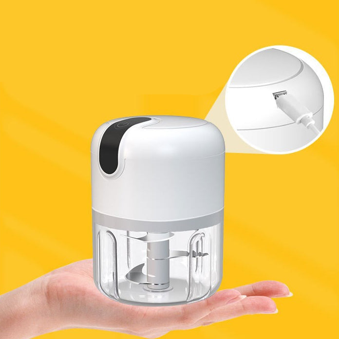 Small electric grinder held in a hand with yellow background.