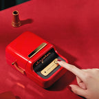 Red label printer with a hand pressing a button on a red background