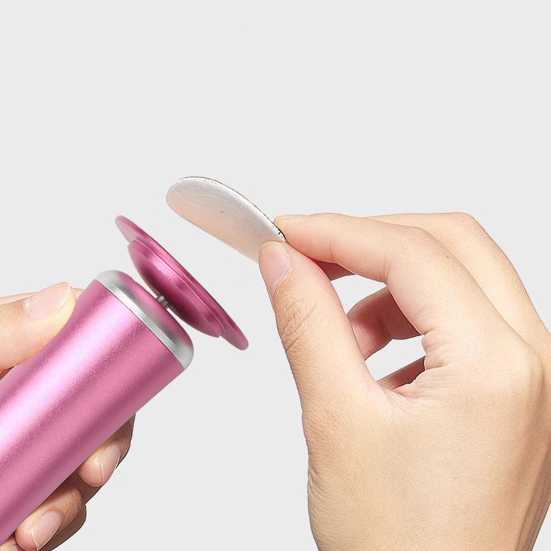 Hand holding a pink container with a small white object, against a light gray background.